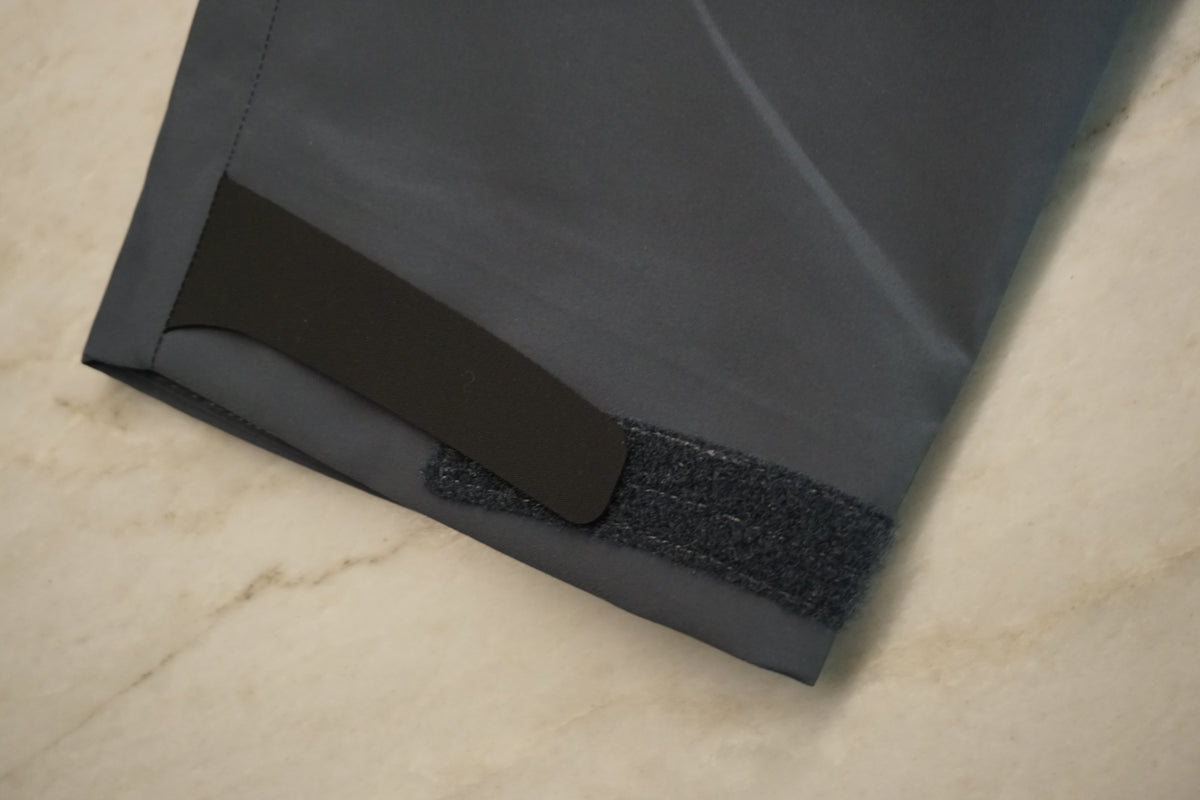 The wrist cuff of a jacket with a velcro adjustment tab.