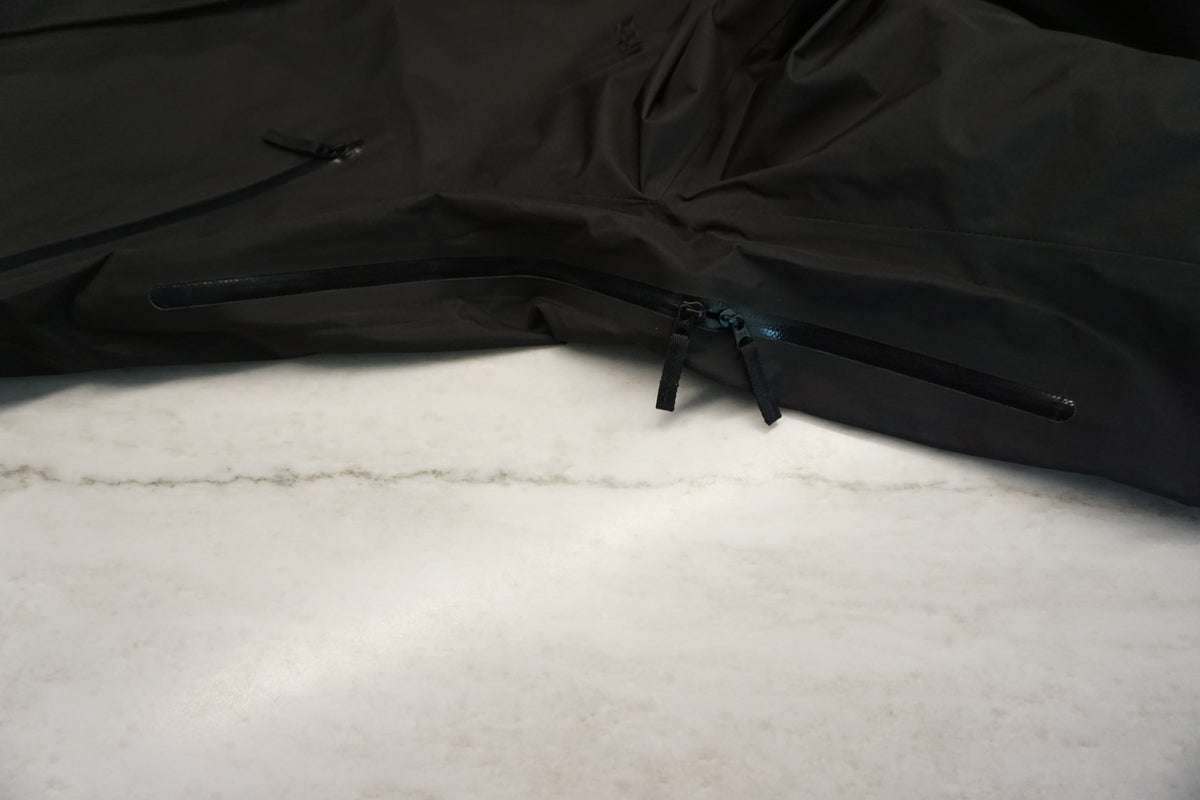 A close up of the pit zippers on a black snow shell.