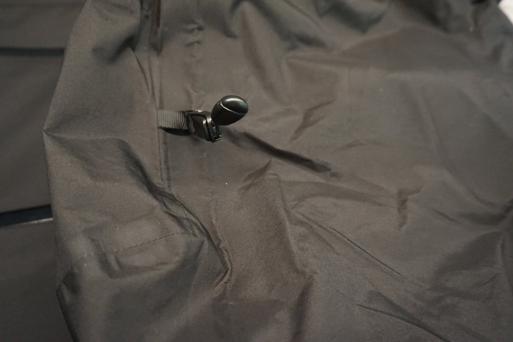 Close-up of the adjustment toggle on the hood of a black shell.