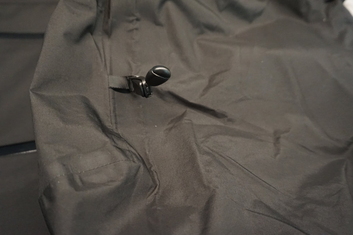 Close-up of the adjustment toggle on the hood of a black shell.