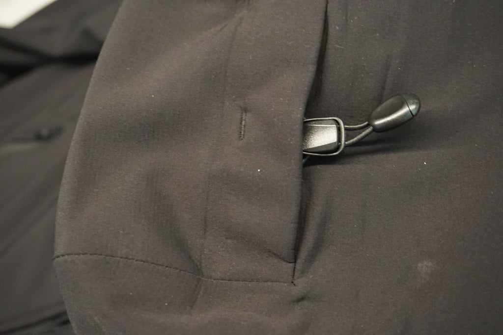 Close-up of a black jacket with a black toggle closure on the hood.